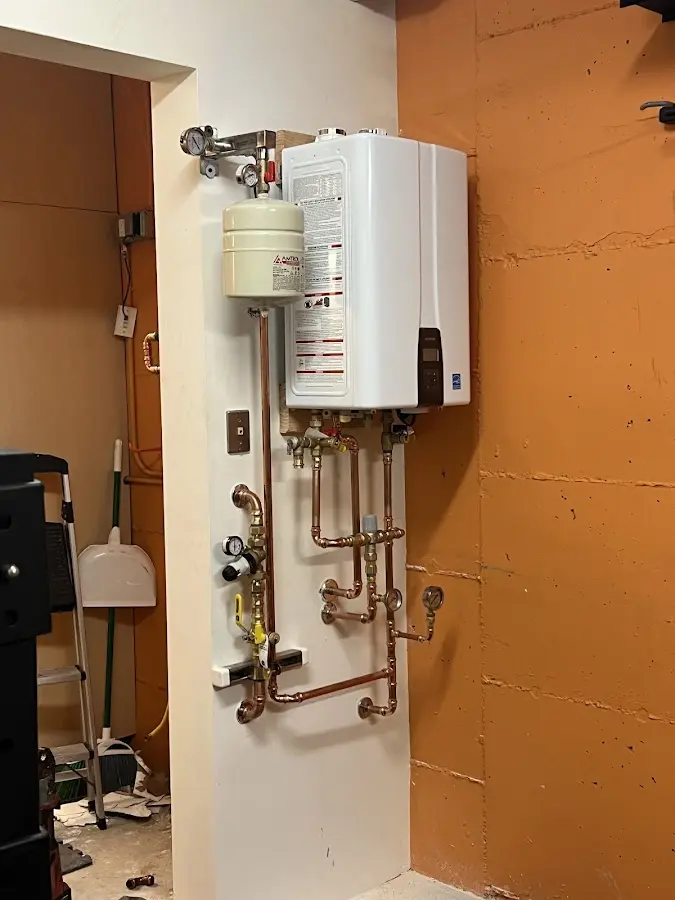 Plumbing technician inspecting water heater connections in Fort Campbell North